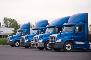 a fleet of trucks idling in a yard