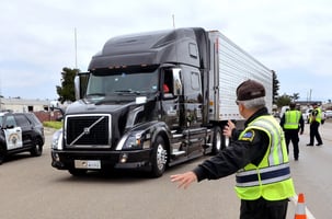 A dot officer pulling an overloaded truck in for inspection