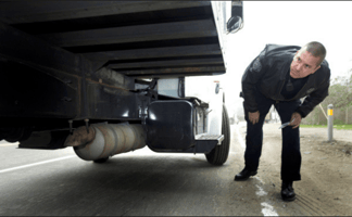 A DOT officer inspecting a truck at roadside